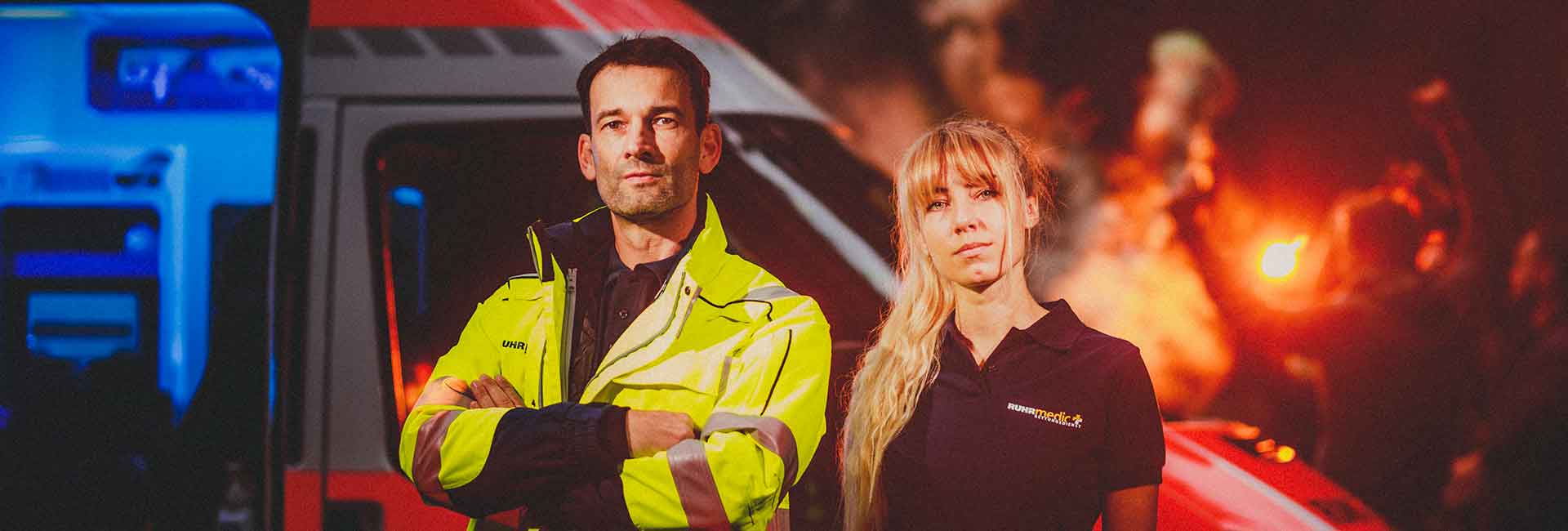 Eine Frau und ein Mann in Uniform vor einem Rettungswagen.